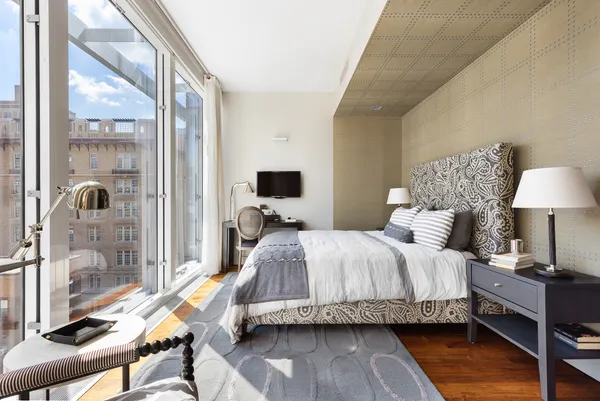 a spacious bedroom with a bed and wooden floor