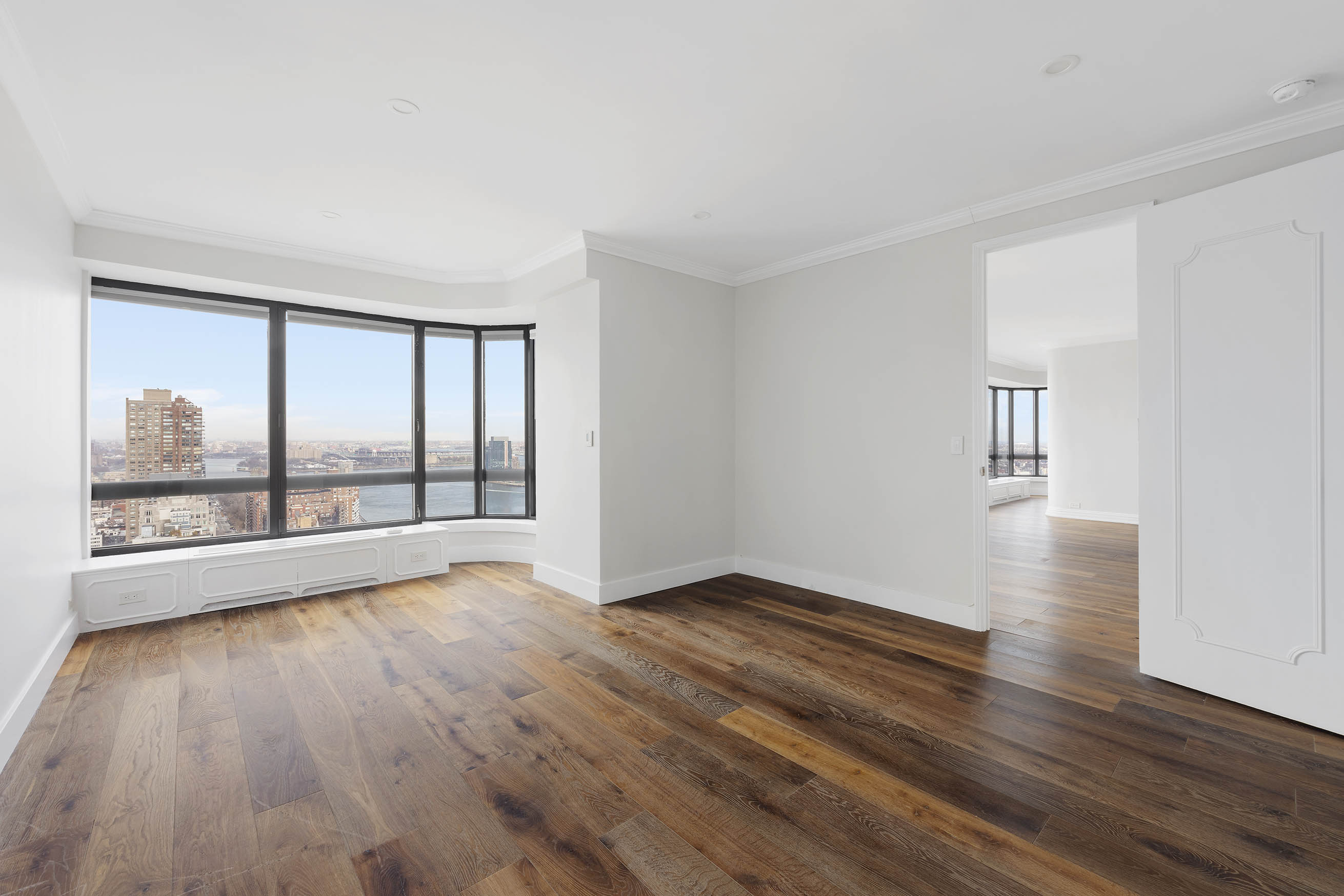 530 East 76th Street, Unit PH36/37E Manhattan, NY 10021 - Photo 9 of 29 a view of an empty room with wooden floor and a window