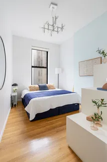 a bedroom with a large bed and a chandelier