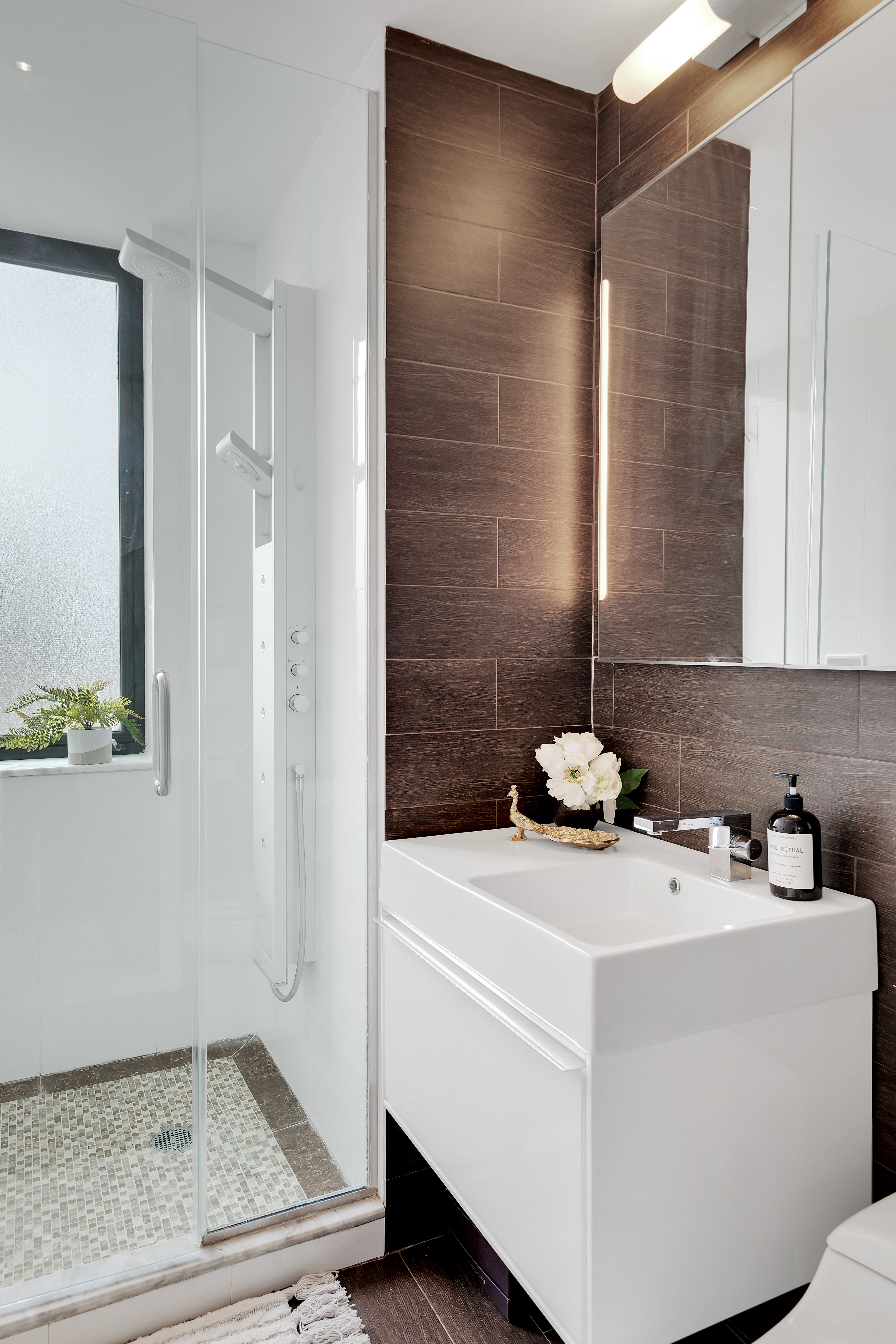 136 East Broadway, Unit PHA Manhattan, NY 10002 - Photo 9 of 12 a bathroom with a sink a toilet and a mirror