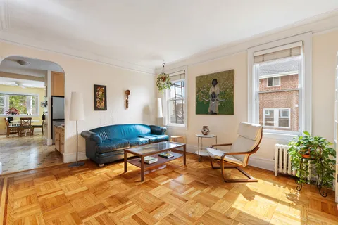 a living room with furniture a piano and a potted plant