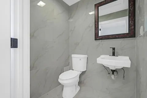 a bathroom with a toilet a sink and mirror