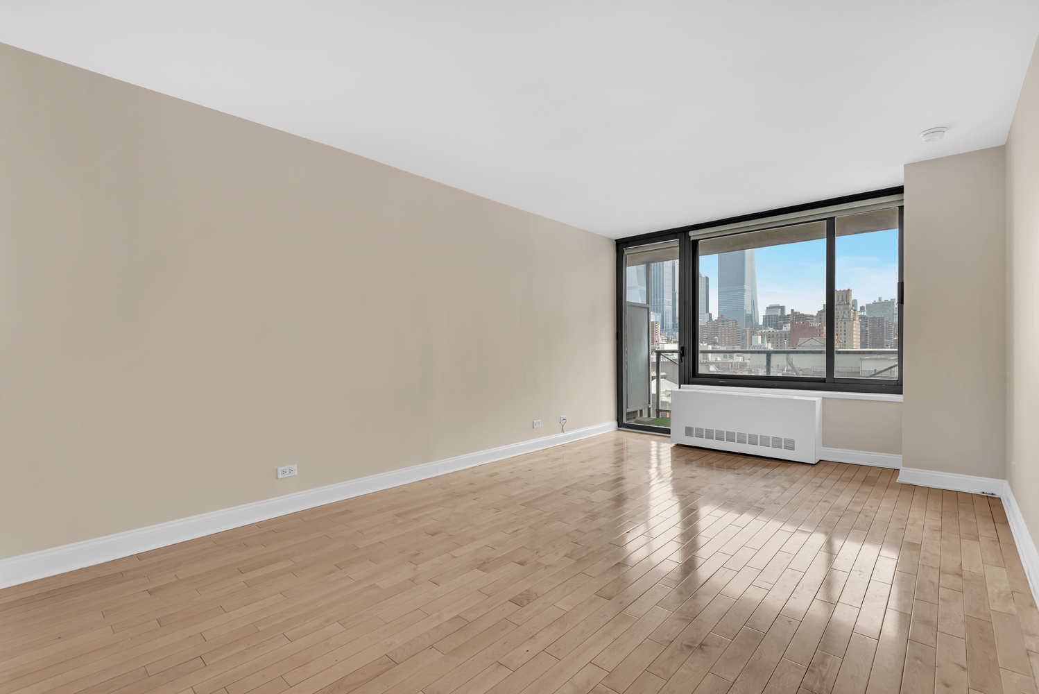 270 West 17th Street, Unit 8B Manhattan, NY 10011 - Photo 5 of 6 a view of an empty room with wooden floor and a window