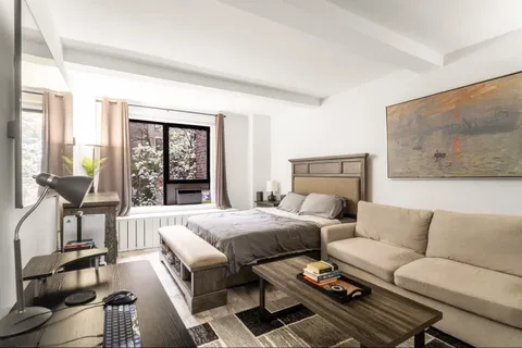 a bedroom with furniture and a large window