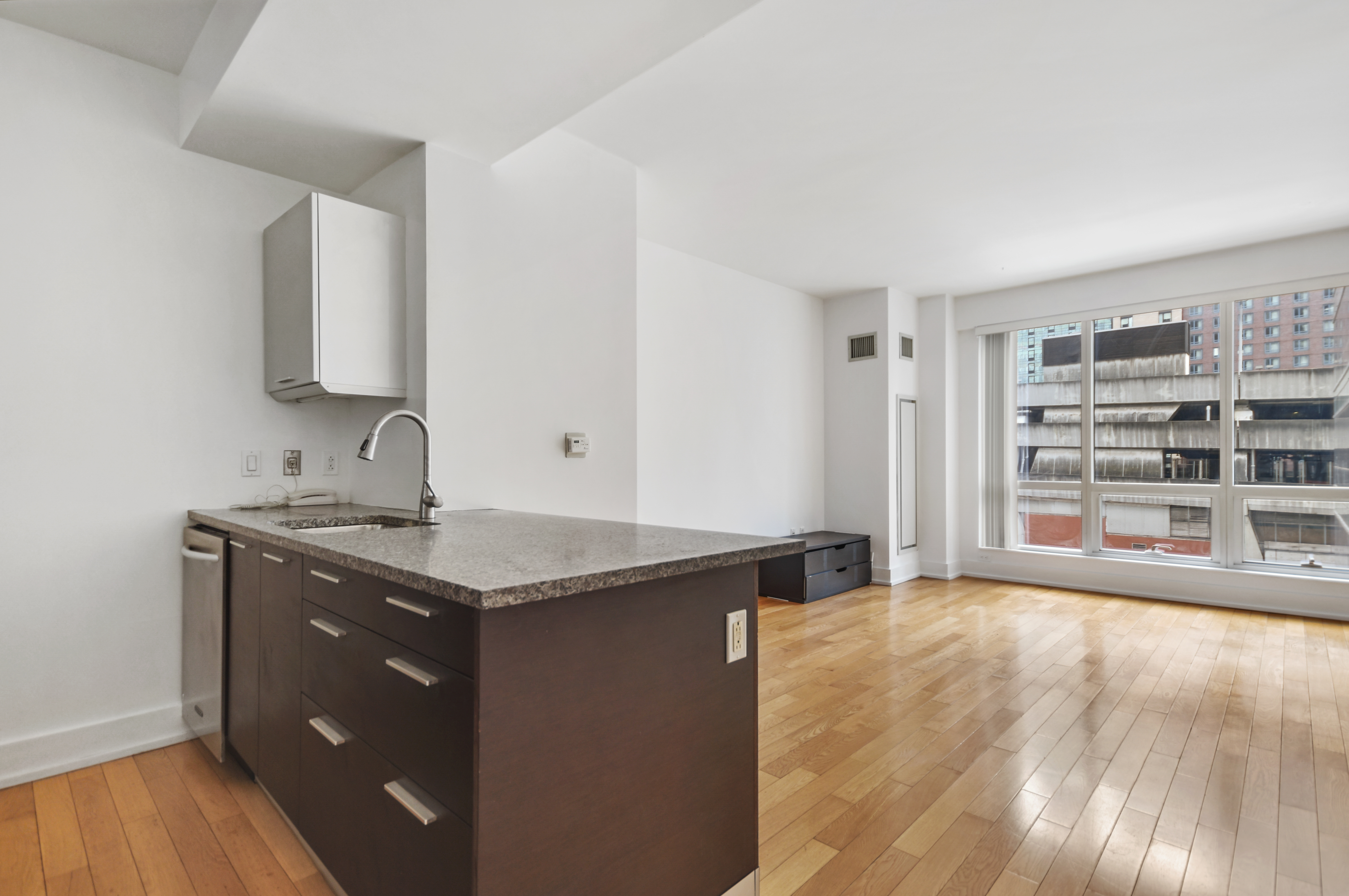 350 West 42nd Street, Unit 8H Manhattan, NY 10036 - Photo 1 of 11 a view of a kitchen with granite countertop a sink and a stove top oven