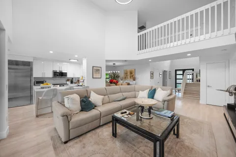 a living room with furniture a floor to ceiling window and a flat screen tv