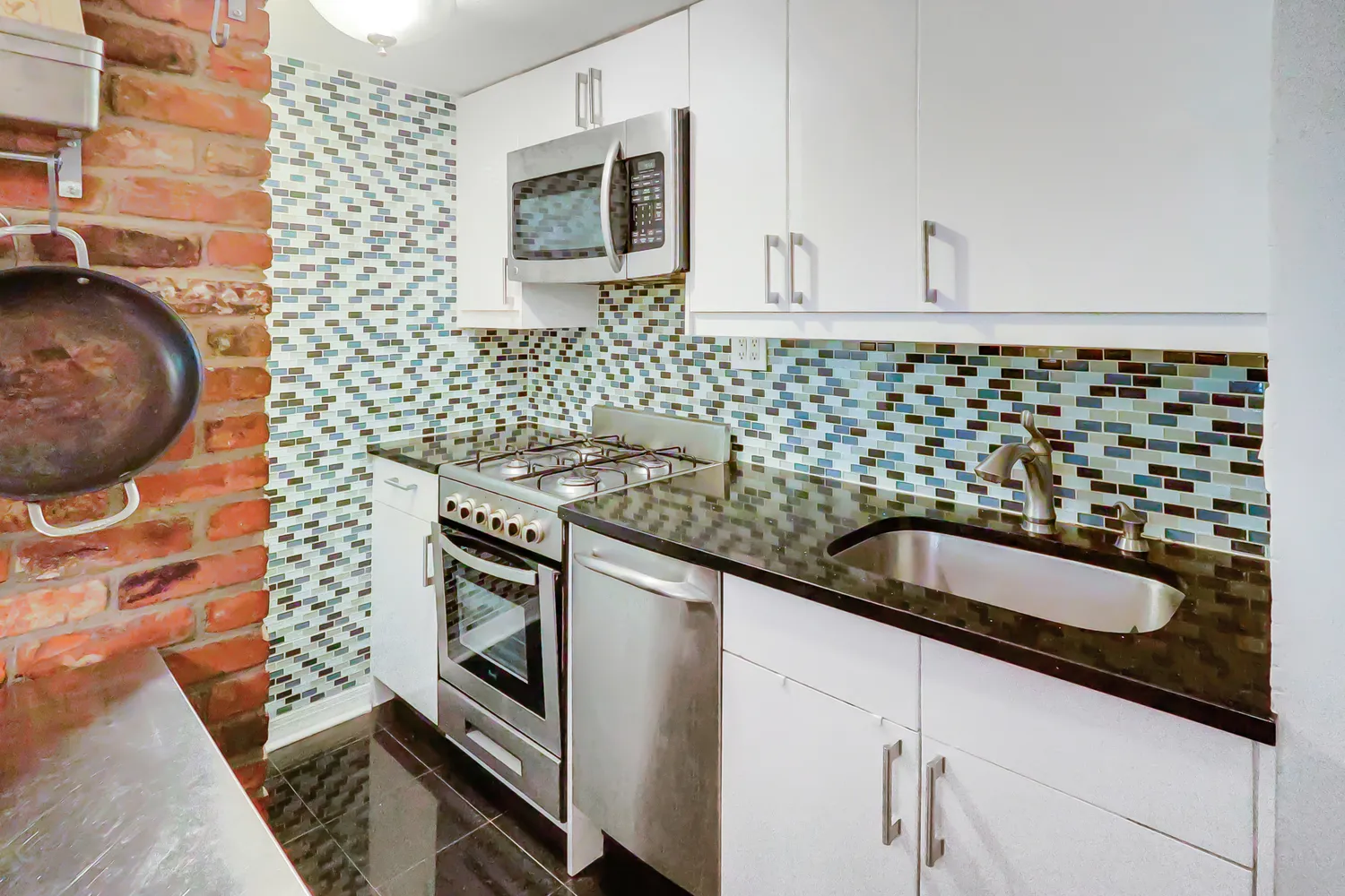 a kitchen with granite countertop a sink and a stove