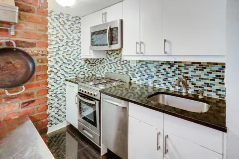 a kitchen with granite countertop a sink and a stove