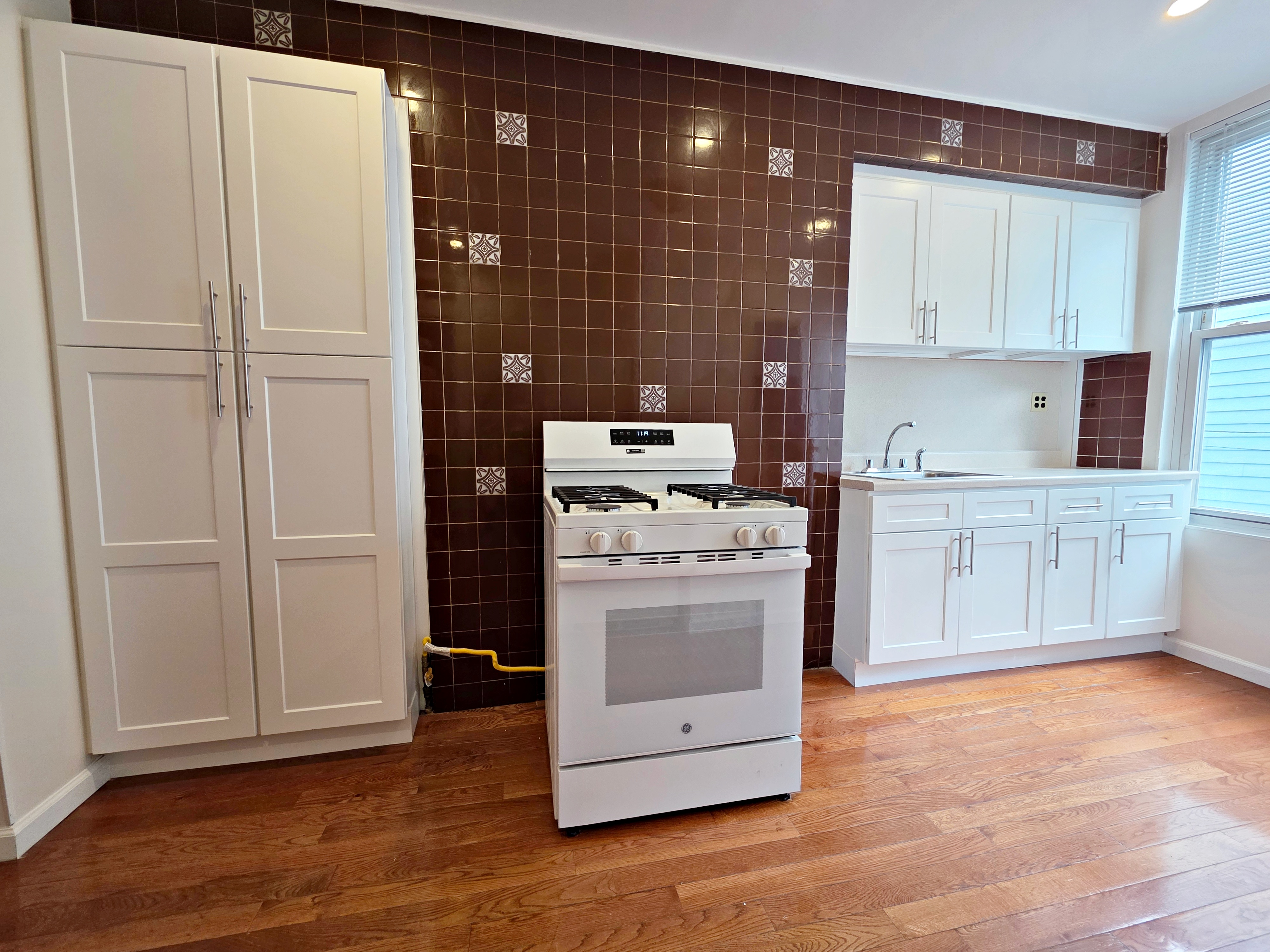 396 Manhattan Avenue, Unit 2L Brooklyn, NY 11211 - Photo 2 of 7 a kitchen with white cabinets and white appliances