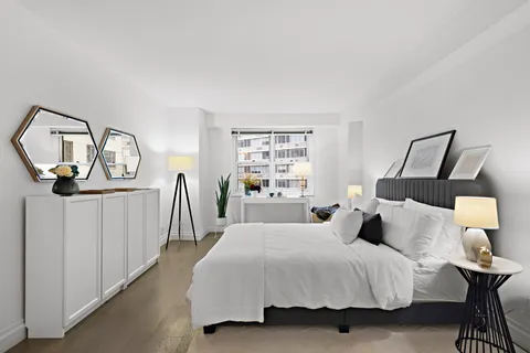 a bedroom with a bed a mirror and window