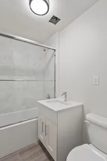 a bathroom with a sink a toilet and shower