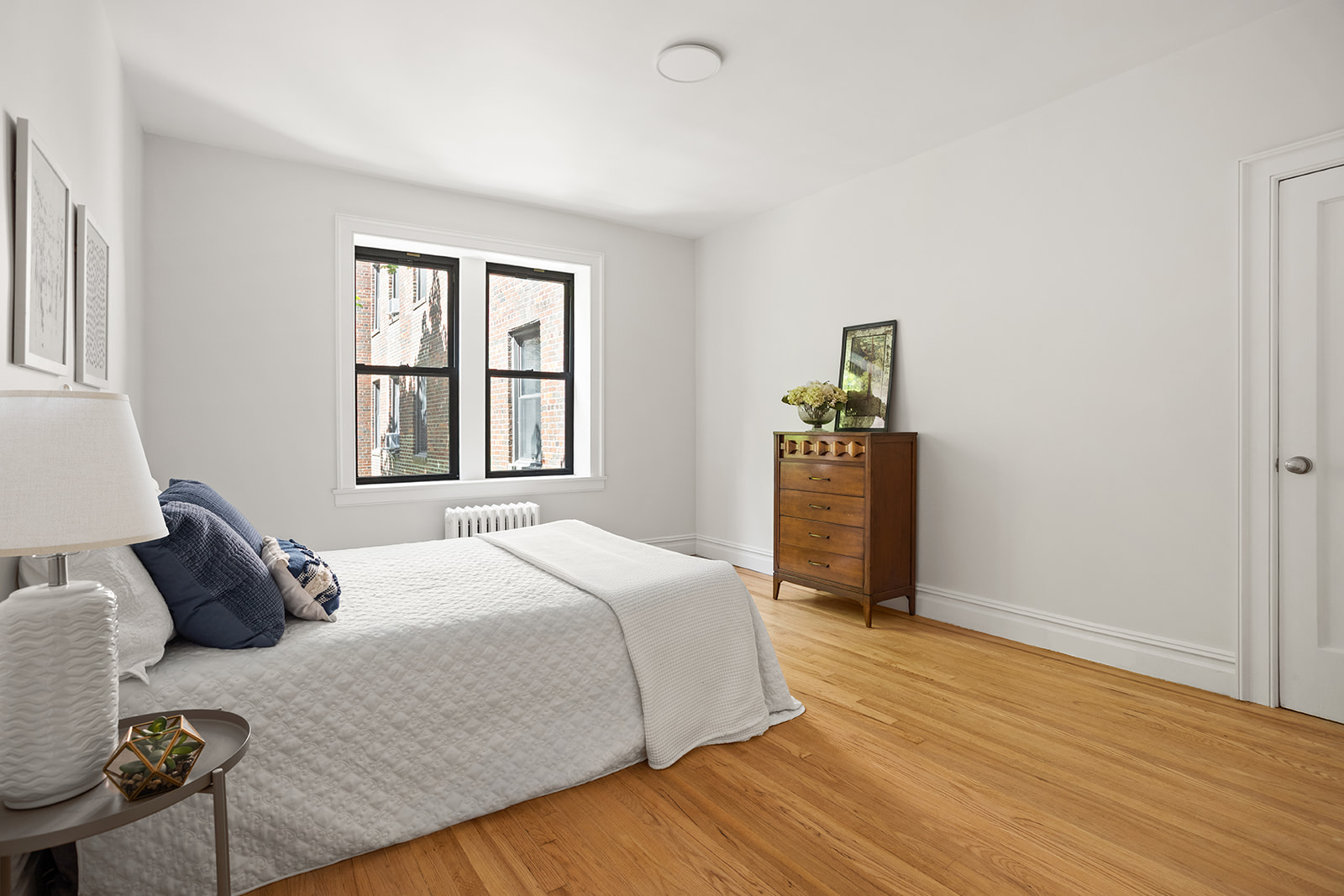 83-10 35th Avenue, Unit 3F Queens, NY 11372 - Photo 6 of 13 a bedroom with a bed and wooden floor