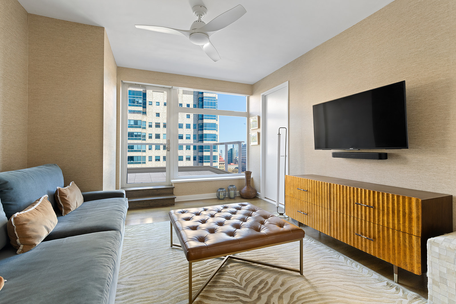 400 East 67th Street, Unit 12D Manhattan, NY 10065 - Photo 6 of 9 a living room with furniture and a flat screen tv