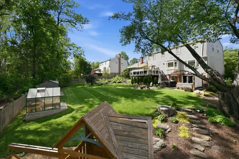 a front view of a house with a yard and trees