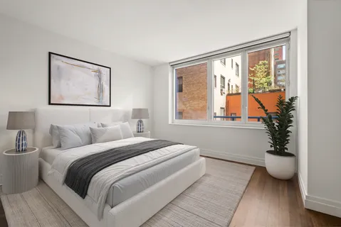 a bedroom with a bed and a large window