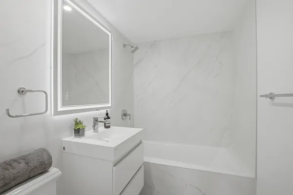 a bathroom with a bathtub sink vanity and mirror