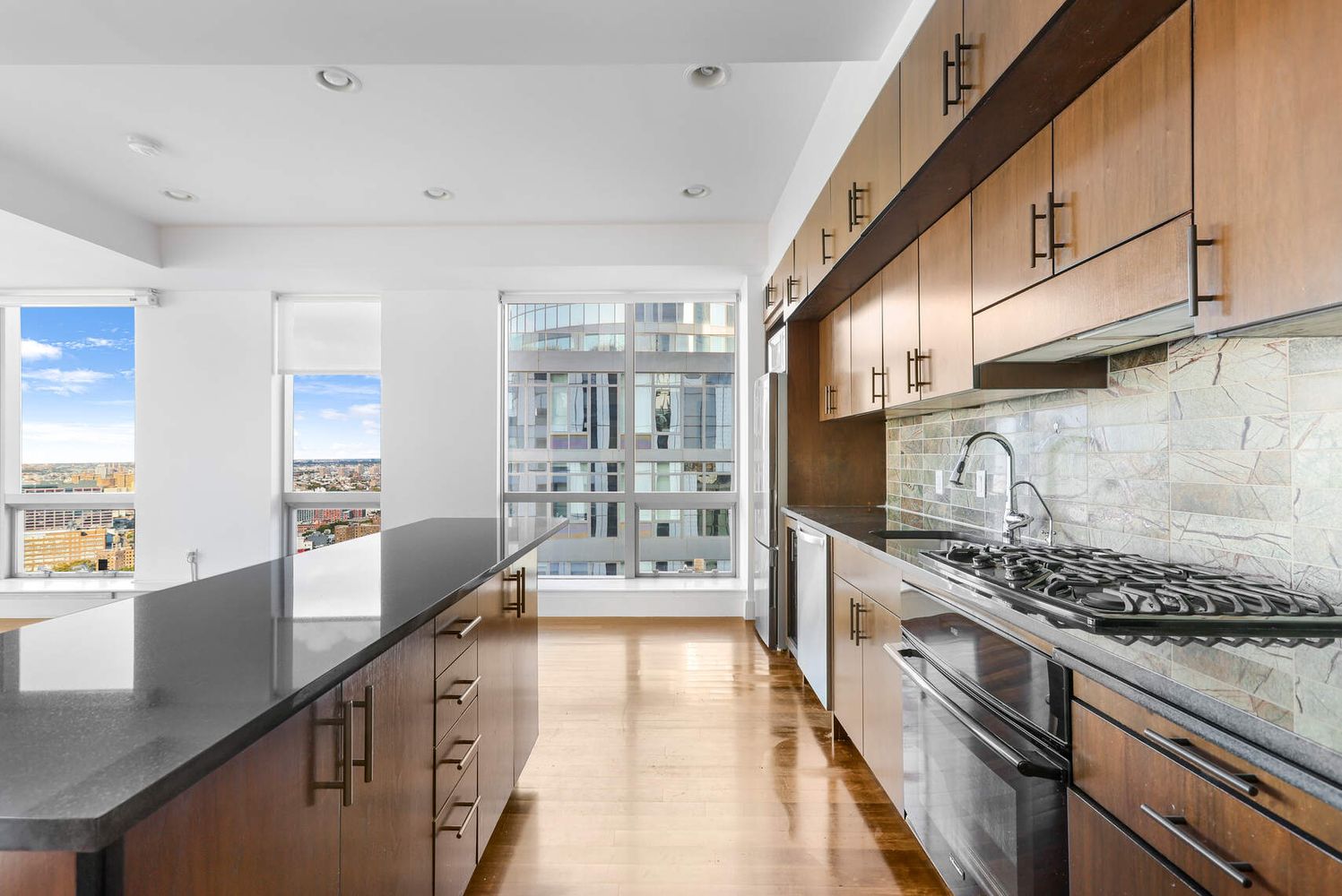 150 Myrtle Avenue, Unit PH3201 Brooklyn, NY 11201 - Photo 9 of 40 a large kitchen with stainless steel appliances granite countertop a lot of counter space and wooden floors