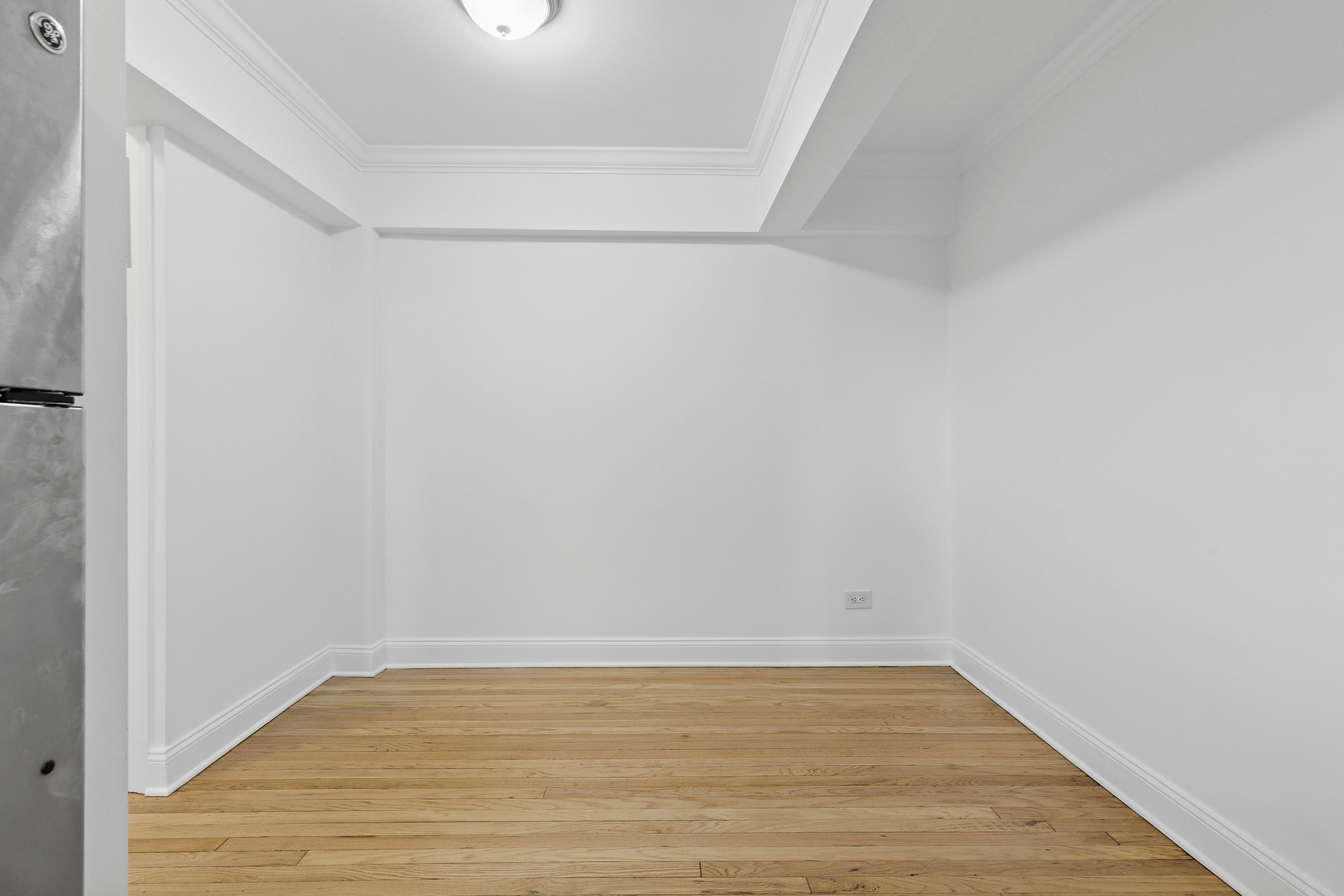 4501 Broadway, Unit 4G Manhattan, NY 10040 - Photo 4 of 7 a view of an empty room with wooden floor