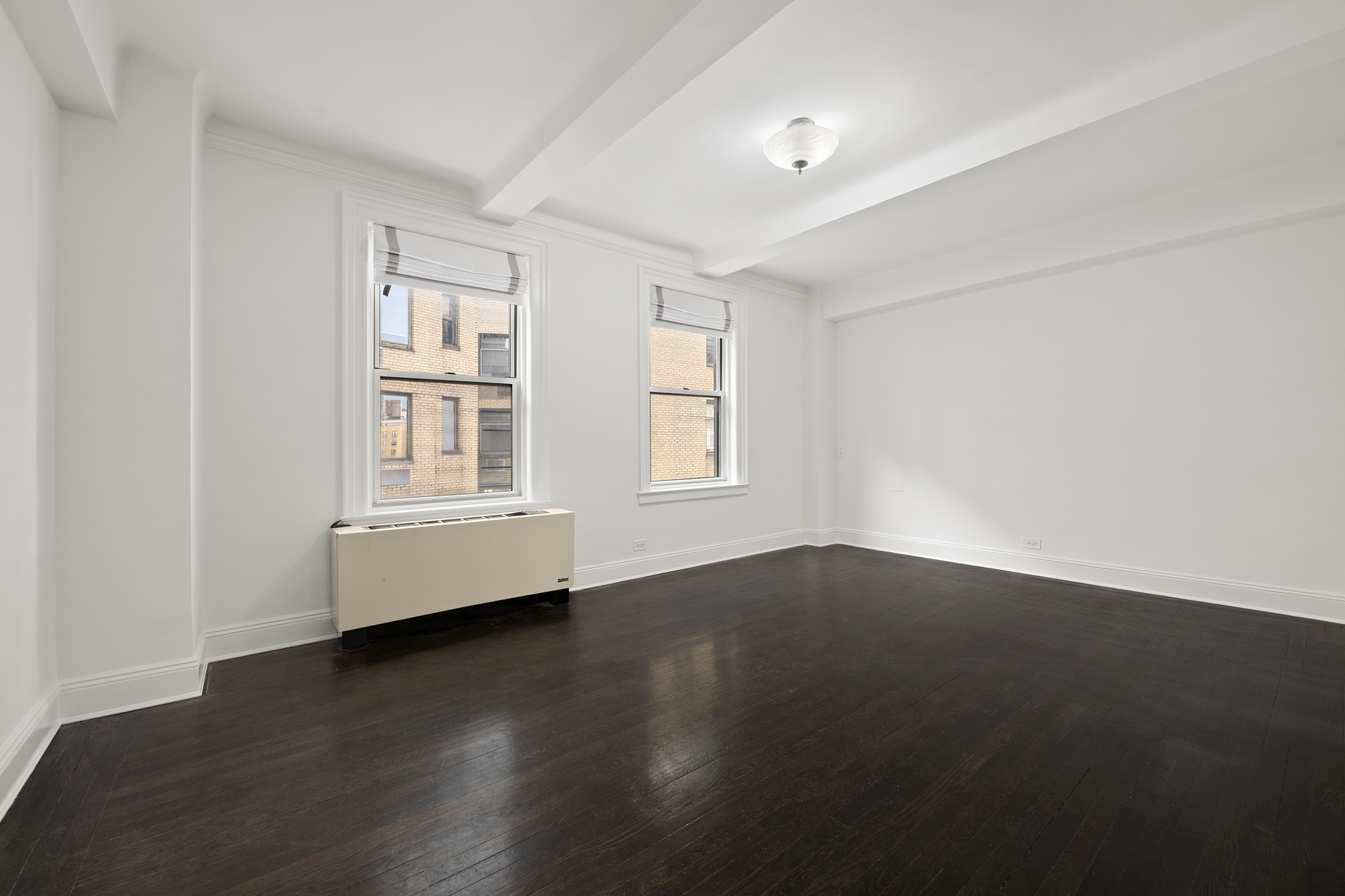 110-118 Riverside Drive, Unit 15C Manhattan, NY 10024 - Photo 5 of 6 a view of an empty room with wooden floor and a window