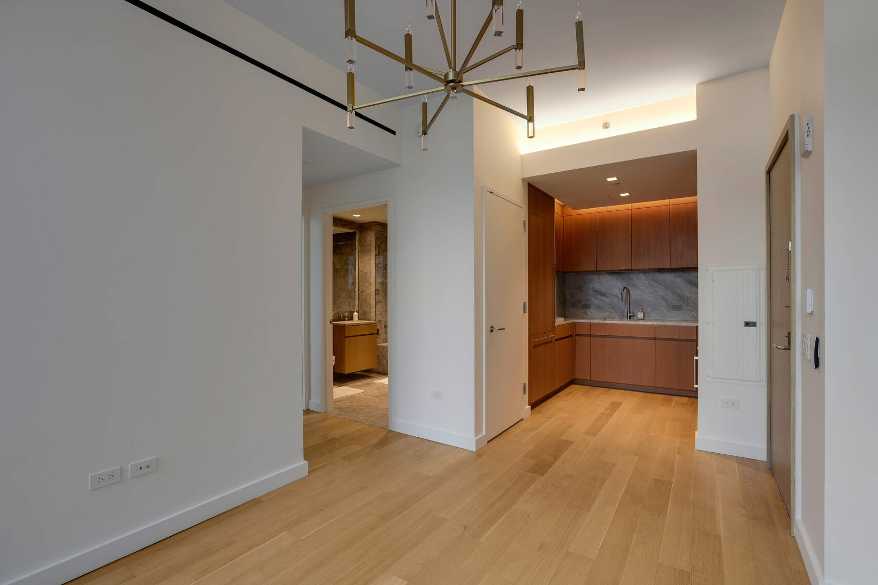 611 West 56th Street, Unit 2D Manhattan, NY 10019 - Photo 4 of 10 a view of a hallway with wooden floor and a kitchen