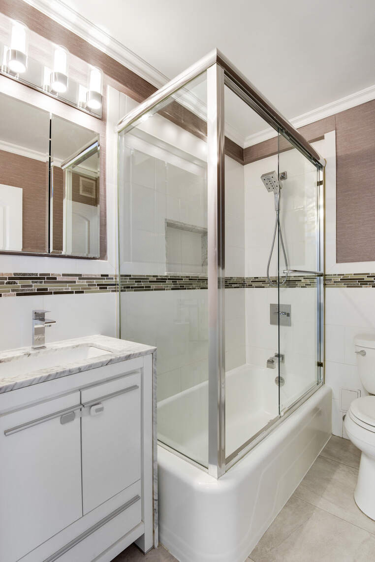 520 East 76th Street, Unit 11C Manhattan, NY 10021 - Photo 9 of 15 a bathroom with a shower sink vanity and mirror