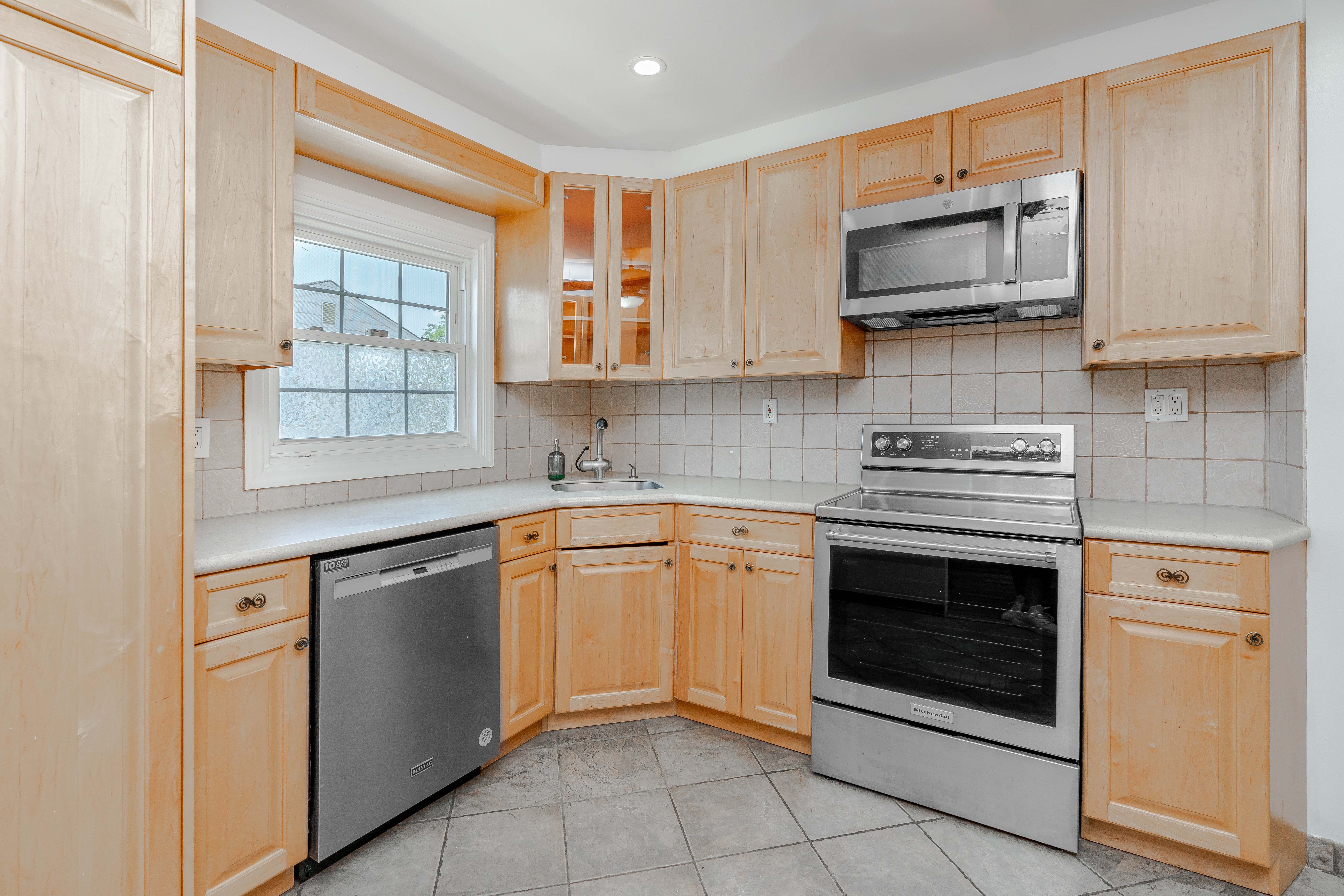 15-80 209th Street, Unit 2 Queens, NY 11360 - Photo 1 of 11 a kitchen with stainless steel appliances granite countertop a stove microwave and sink