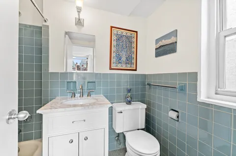 a bathroom with a toilet sink and mirror