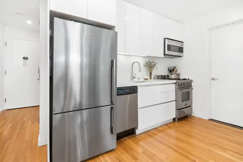 a kitchen with stainless steel appliances a refrigerator sink and cabinets