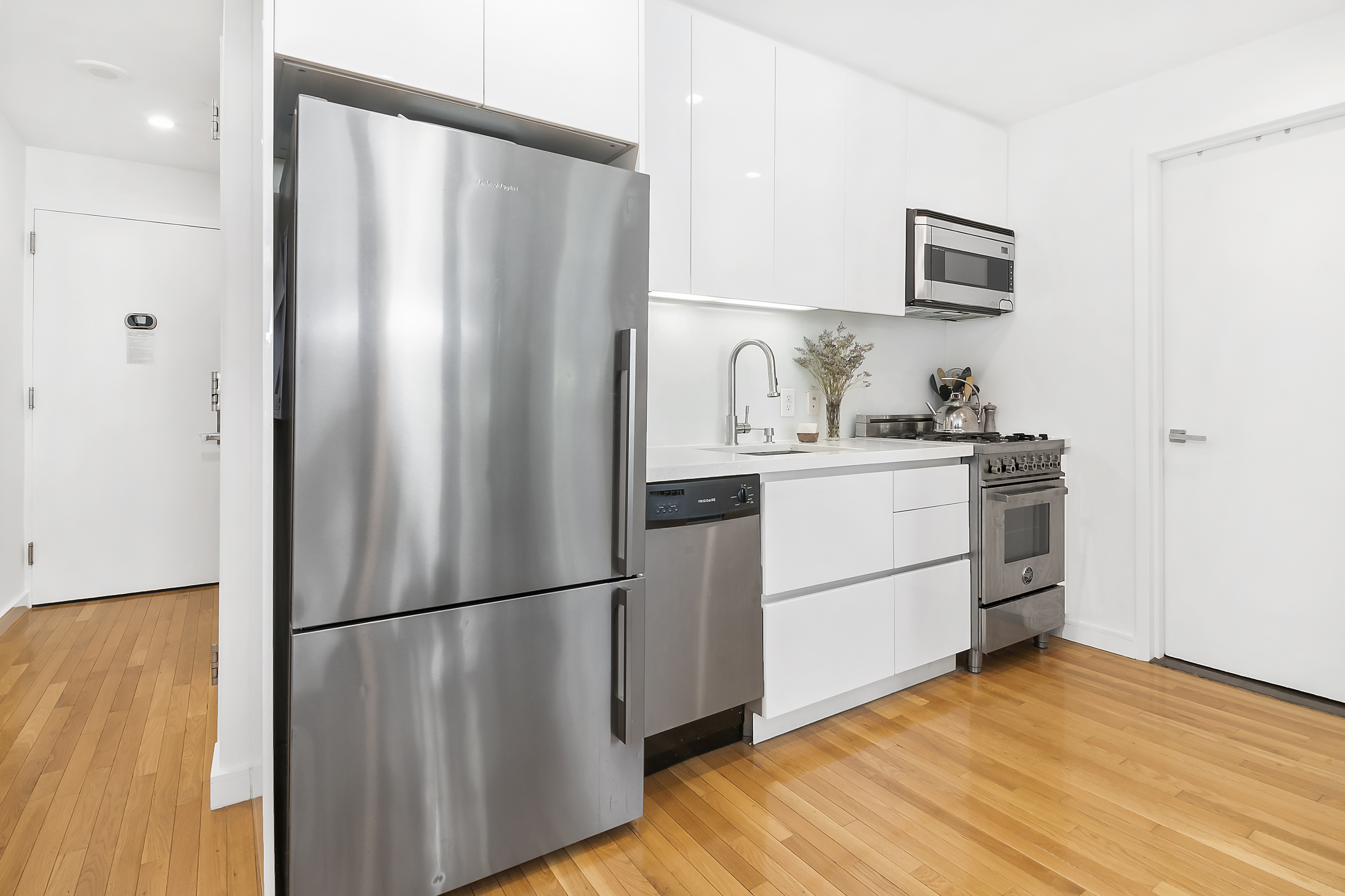 148 East 24th Street, Unit 3F Manhattan, NY 10010 - Photo 7 of 9 a kitchen with stainless steel appliances a refrigerator sink and cabinets