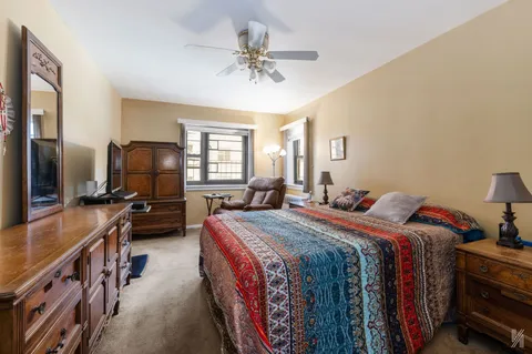 a bed room with bed and a flat tv screen on a dresser
