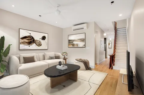 a living room with furniture and a painting on the wall