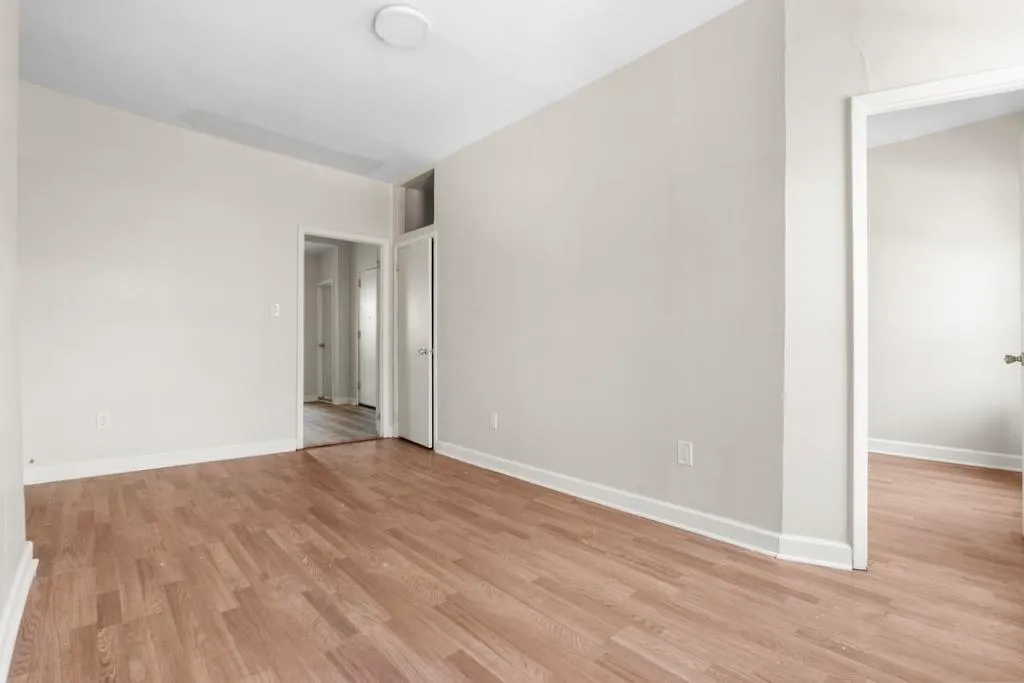 a view of an empty room with wooden floor