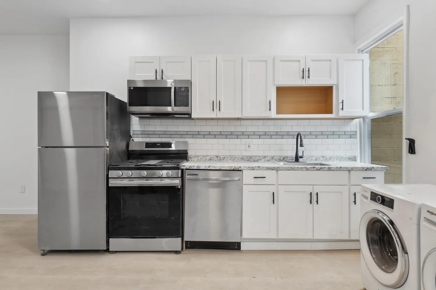a kitchen with stainless steel appliances granite countertop a refrigerator stove and sink