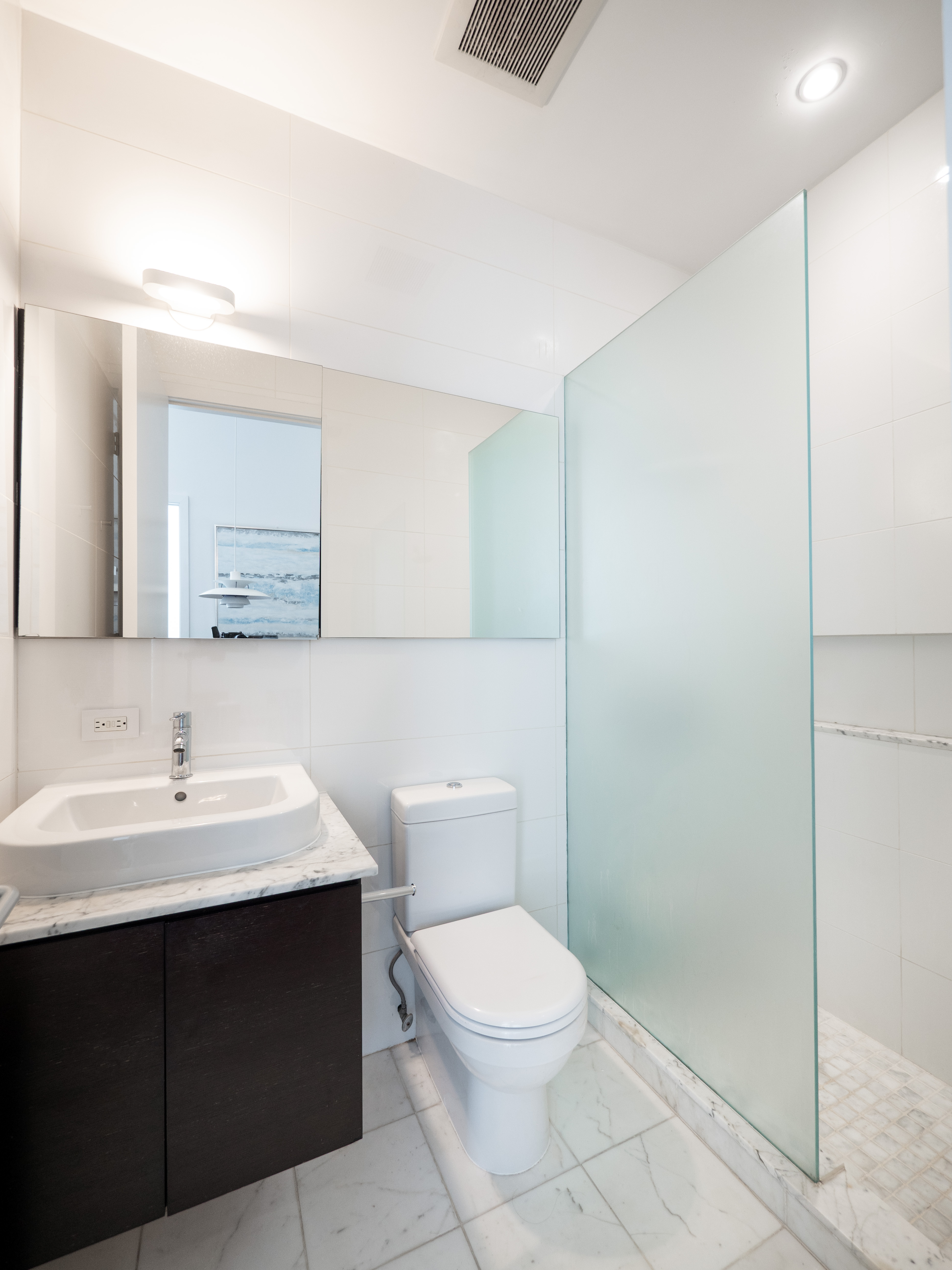 120 East 87th Street, Unit R6IJ Manhattan, NY 10128 - Photo 18 of 27 a bathroom with a toilet a sink a mirror and vanity
