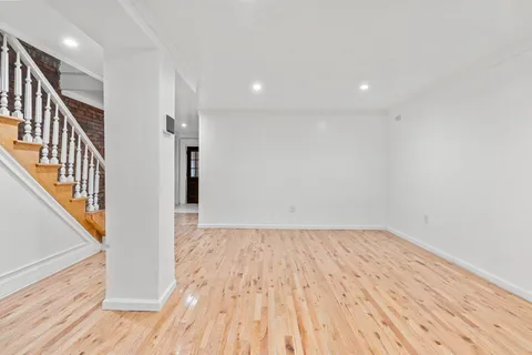 a view of a hallway with wooden floor and staircase