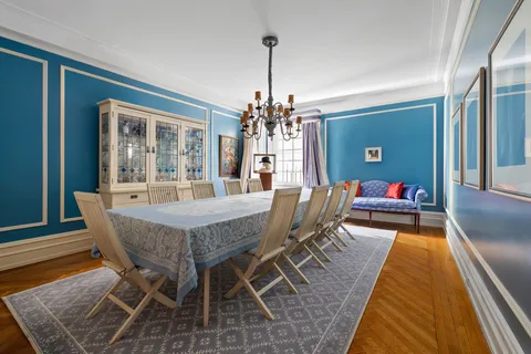 a dining room with furniture a chandelier and wooden floor
