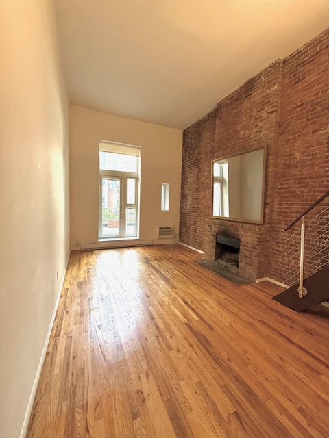 223 West 14th Street, Unit 1B Manhattan, NY 10011 - Photo 3 of 10 a view of an empty room with wooden floor and a window