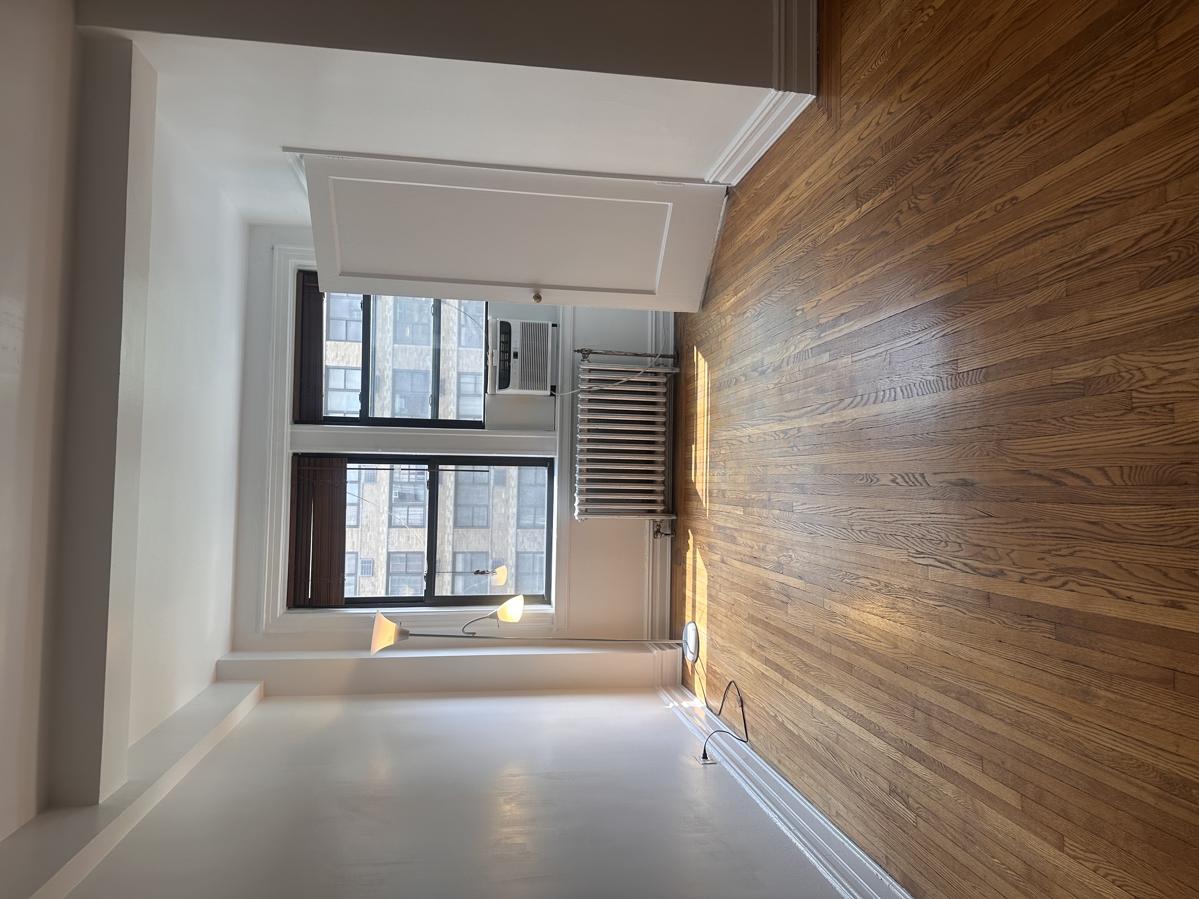 457 West 57th Street, Unit 505 Manhattan, NY 10019 - Photo 8 of 10 a view of empty room with wooden floor and fan