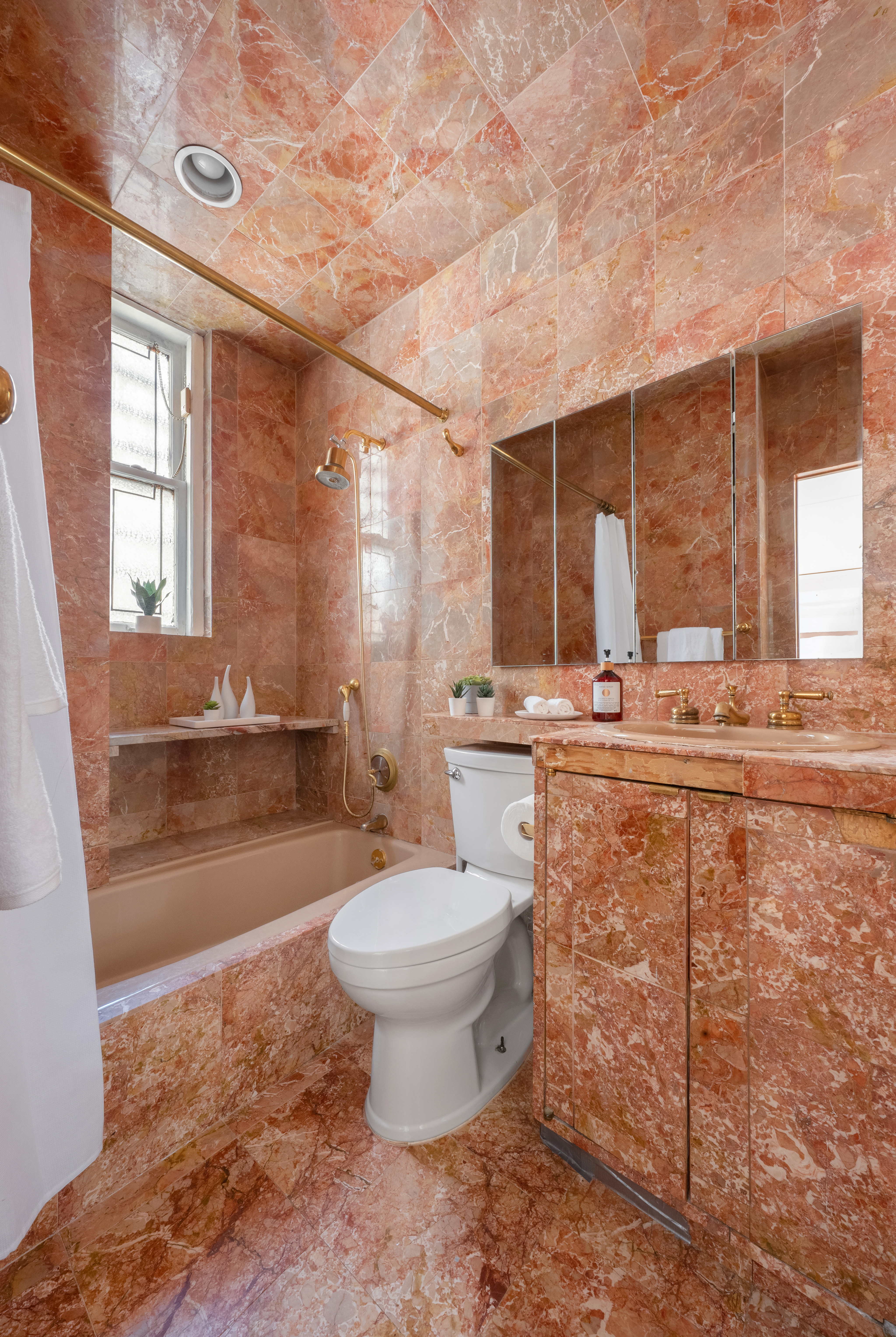 1060 Park Avenue, Unit 11A Manhattan, NY 10128 - Photo 9 of 12 a bathroom with a granite countertop toilet a sink and a bathtub