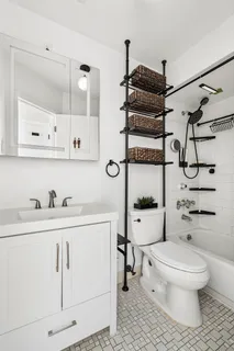 a bathroom with a toilet a sink a mirror and shower