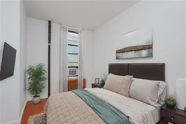 a bedroom with a bed and a flat screen tv