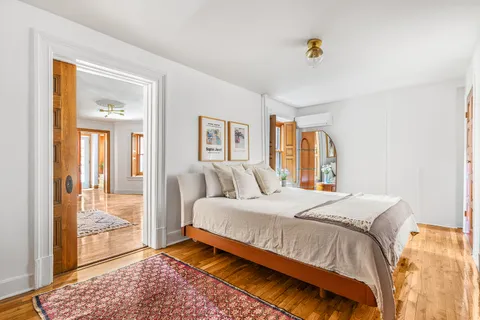 a bedroom with a bed and wooden floor