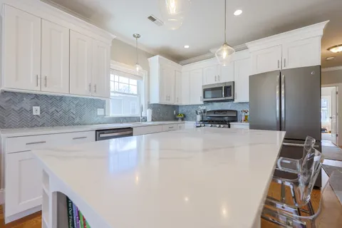 a kitchen with stainless steel appliances a refrigerator sink and microwave