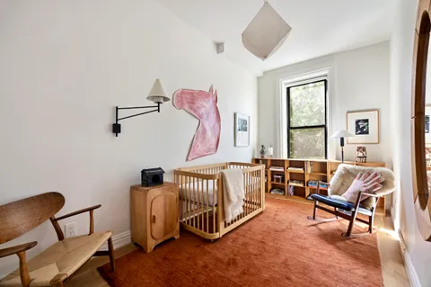 a bedroom with furniture and a large window