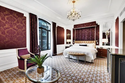 a spacious bedroom with a large bed and a chandelier