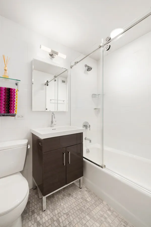 a bathroom with a sink vanity mirror and toilet