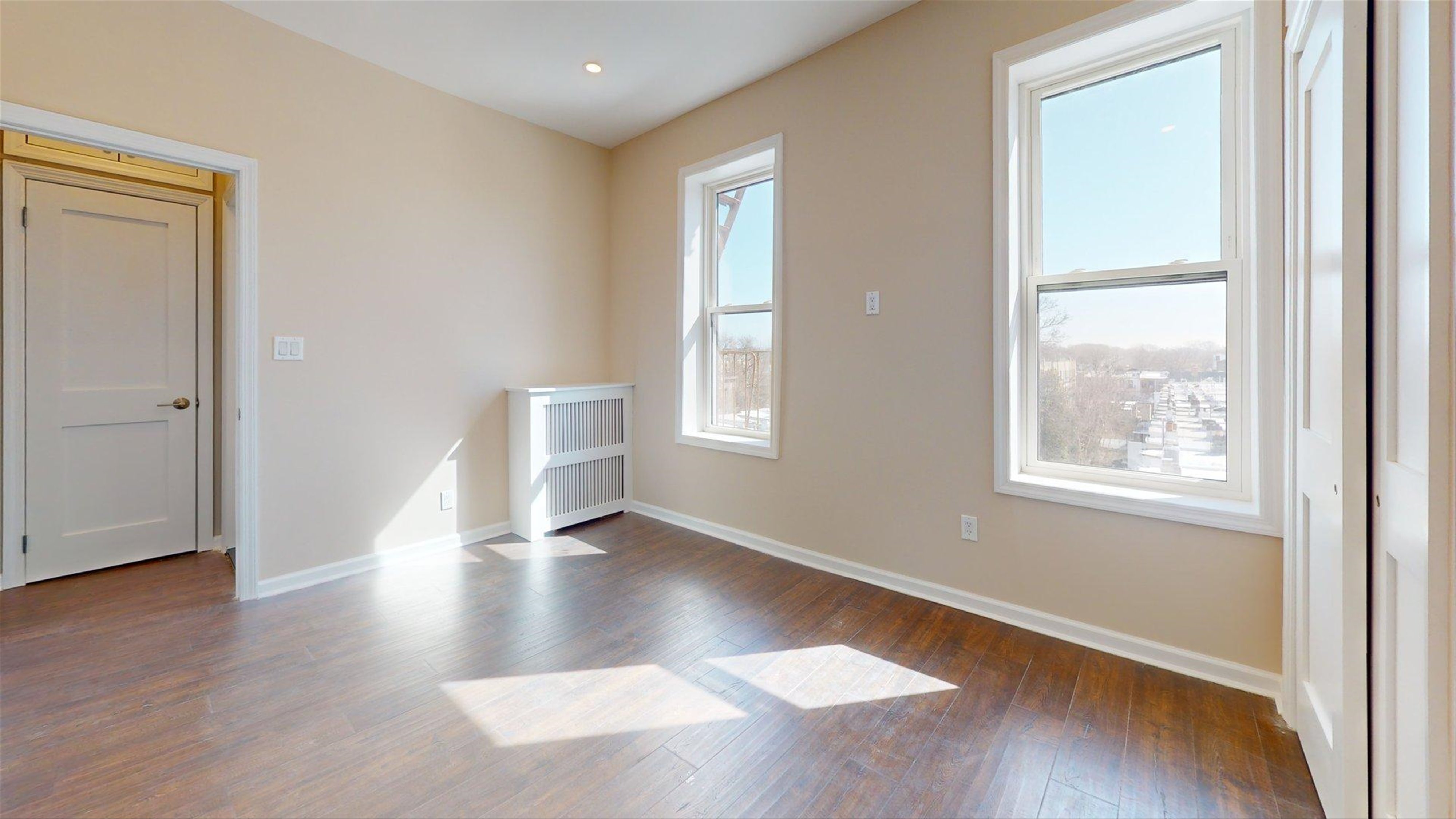 7609 4th Avenue, Unit E14 Brooklyn, NY 11209 - Photo 6 of 15 an empty room with wooden floor and windows