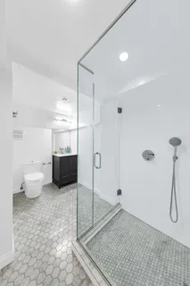 a bathroom with a granite countertop sink a toilet and a shower