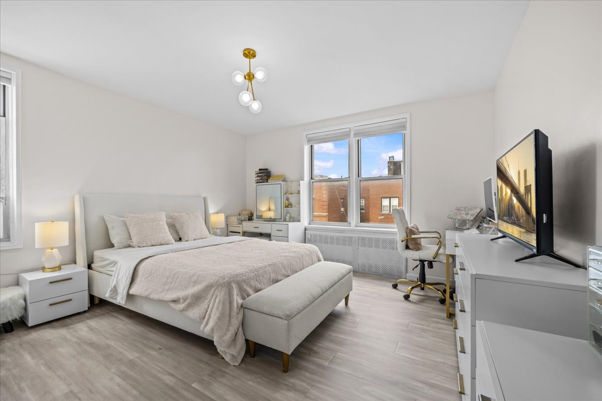 759 East 10th Street, Unit 7H Brooklyn, NY 11230 - Photo 7 of 15 a spacious bedroom with a bed and a flat screen tv