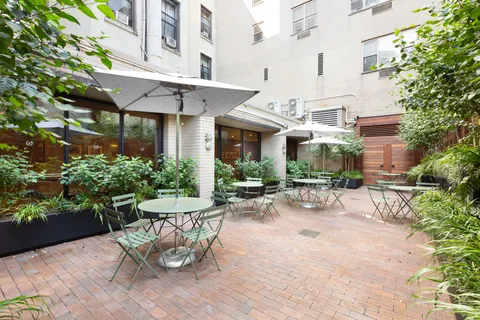 a view of a patio with a table and chairs and potted plants